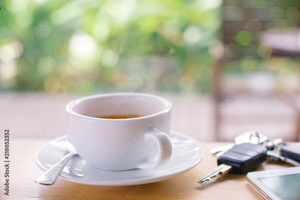 Cup of hot coffee Smart phone and car key on wood table.Selective focus Cup of hot coffee Smart phone and car key on wood table.Selective focus