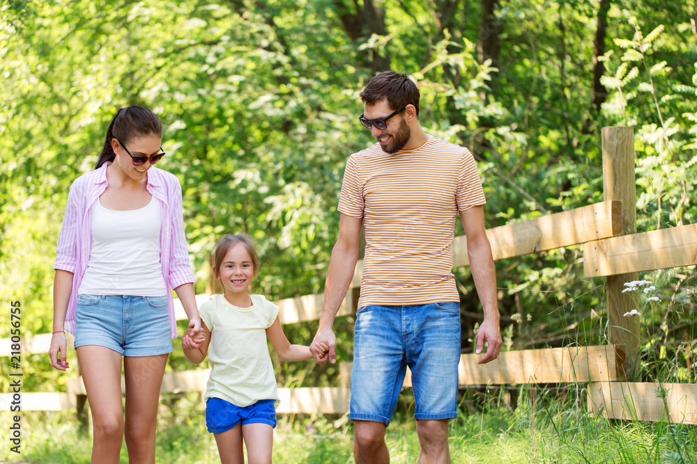 family, leisure and people concept - happy mother, father and little daughter walking in summer park family, leisure and people concept - happy mother, father and little daughter walking in summer park