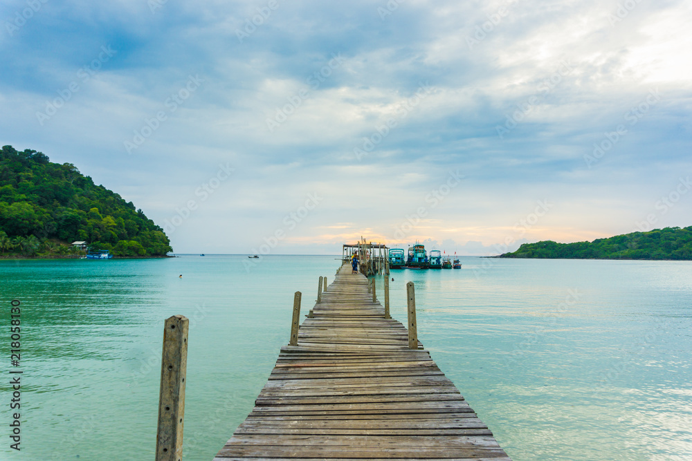 Fototapeta premium Wooden sea bridge to bay sunset sky with cloud