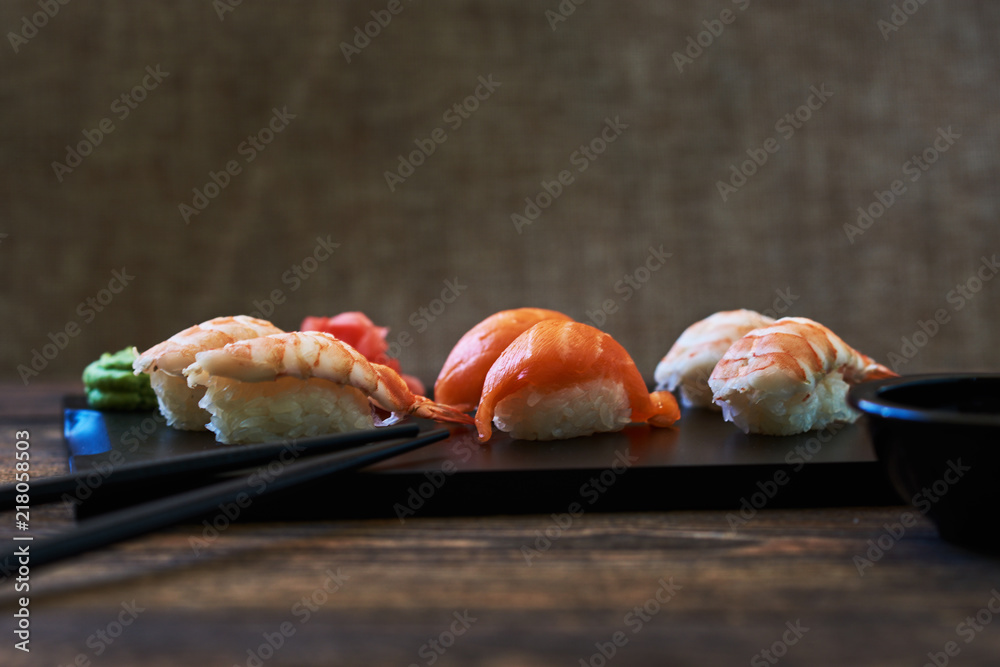 Plate of sushi rolls. Sushi set sashimi and sushi rolls served on wooden plate. Sushi rolls with salmon, eel, tuna, avocado, royal prawn, cream cheese caviar tobica, chuka. Sushi menu. Japanese food. Plate of sushi rolls. Sushi set sashimi and sushi rolls served on wooden plate. Sushi rolls with salmon, eel, tuna, avocado, royal prawn, cream cheese caviar tobica, chuka. Sushi menu. Japanese food.