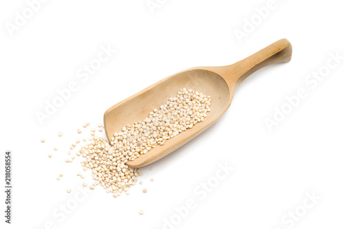 Wooden spoon or scoop with healthy quinoa seeds isolated on white background