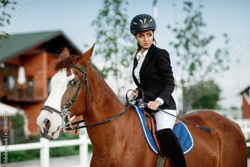 Fototapeta Naklejka Na Ścianę i Meble -  Rider elegant woman riding her horse outside