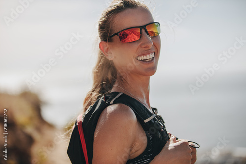 Fototapeta Naklejka Na Ścianę i Meble -  Female mountain runner smiling at camera