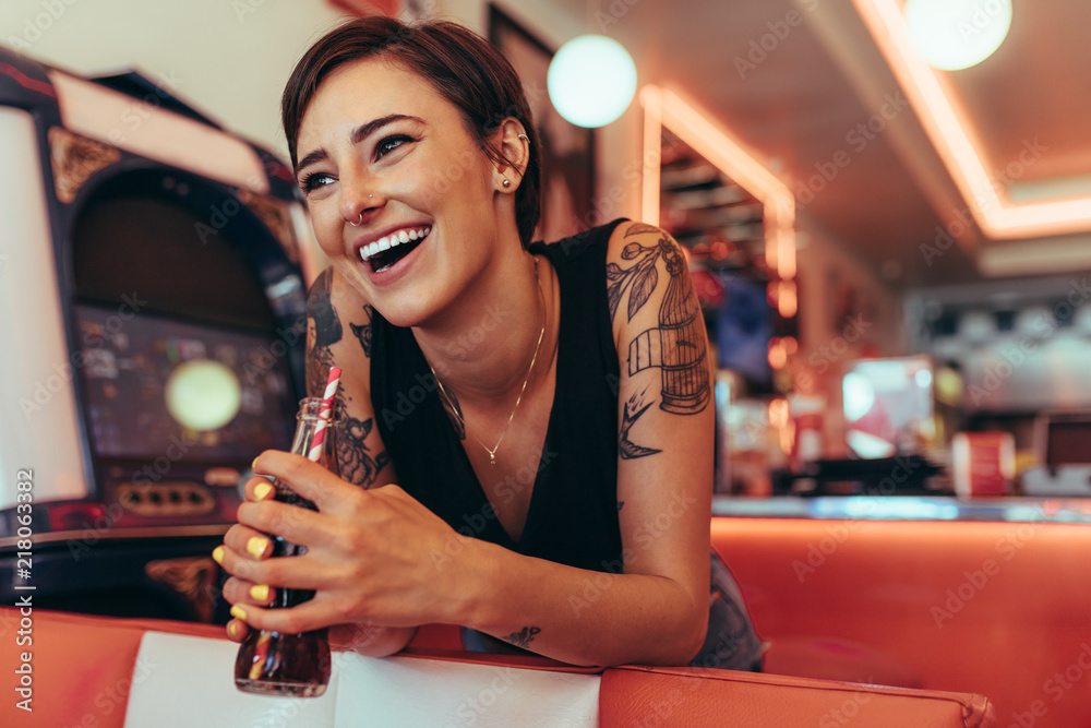 Woman at a restaurant holding a soft drink - obrazy, fototapety, plakaty 