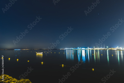 beautiful lights of the city at sunrise with a blue light on the water and the sky
