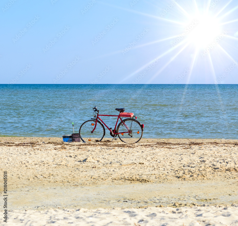Fototapeta premium old red bicycle standing by the sea