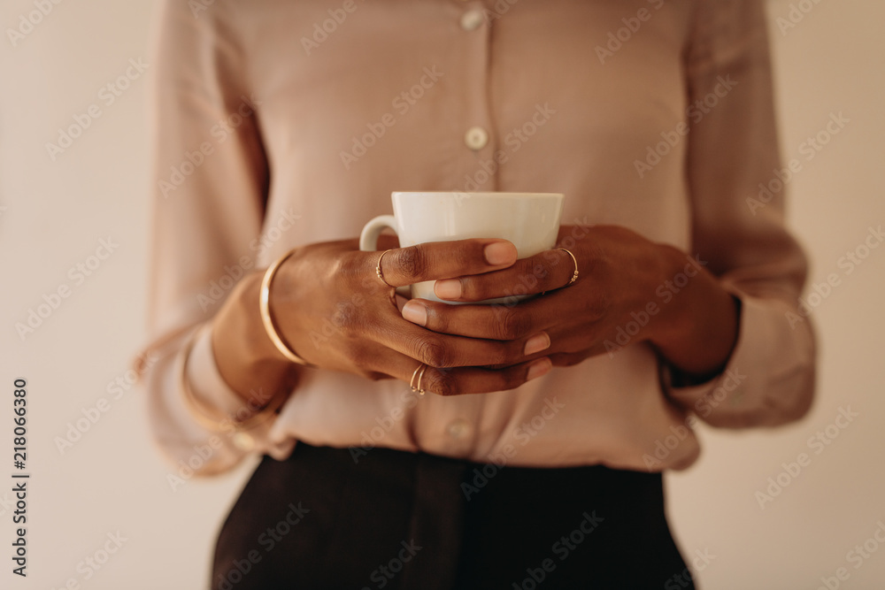 Woman in formal attire holding a coffee cup Woman in formal attire holding a coffee cup