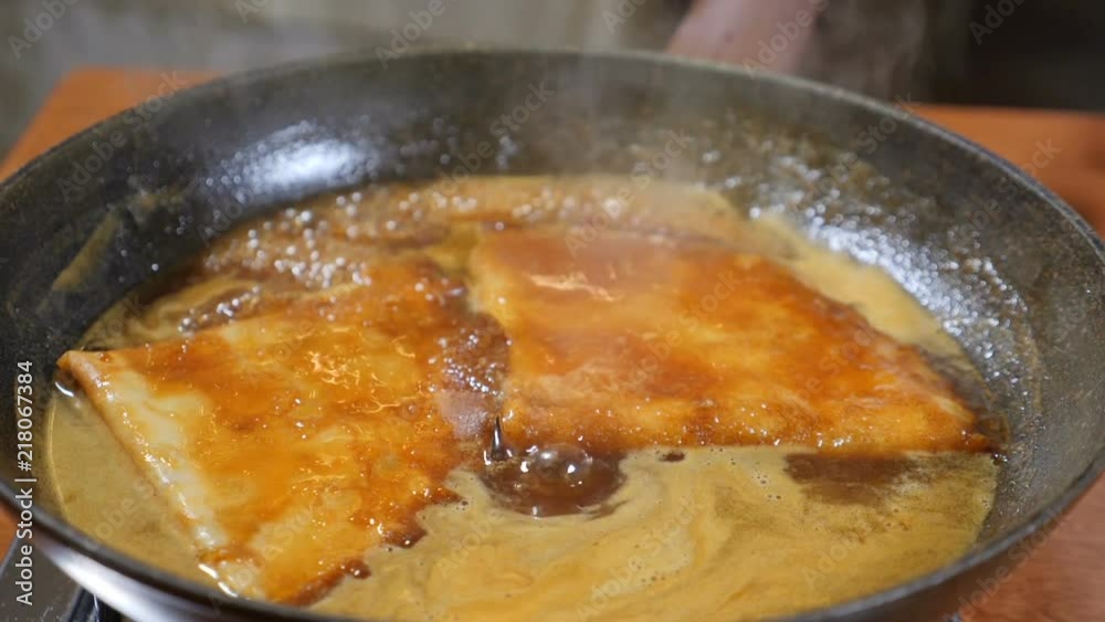 Restaurant cooking concept. Pancakes in boiling caramel sauce. Slow motion Restaurant cooking concept. Pancakes in boiling caramel sauce. Slow motion