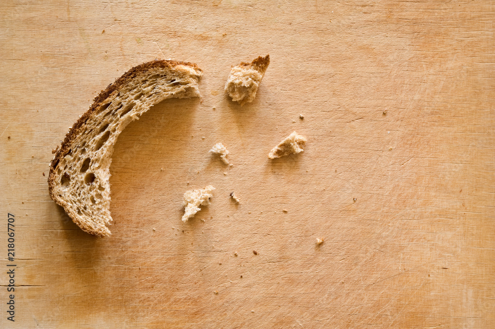 Partially eaten bread on wooden cutting board. Partially eaten bread on wooden cutting board.