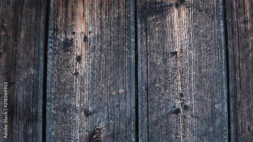 The old gray wood is darkened from time to board with knots, a wooden vintage background, the camera moves from the right to the left. The old gray wood is darkened from time to board with knots, a wooden vintage background, the camera moves from the right to the left.