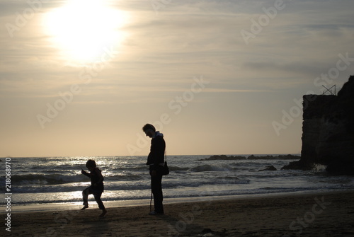 Famiglia che gioca sulla spiaggia - silouette