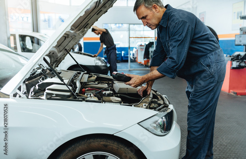 Mechanic reading the error codes with diagnostic device