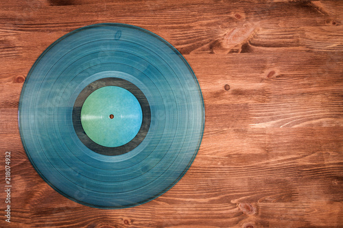 Cyan vinyl record on brown wooden background