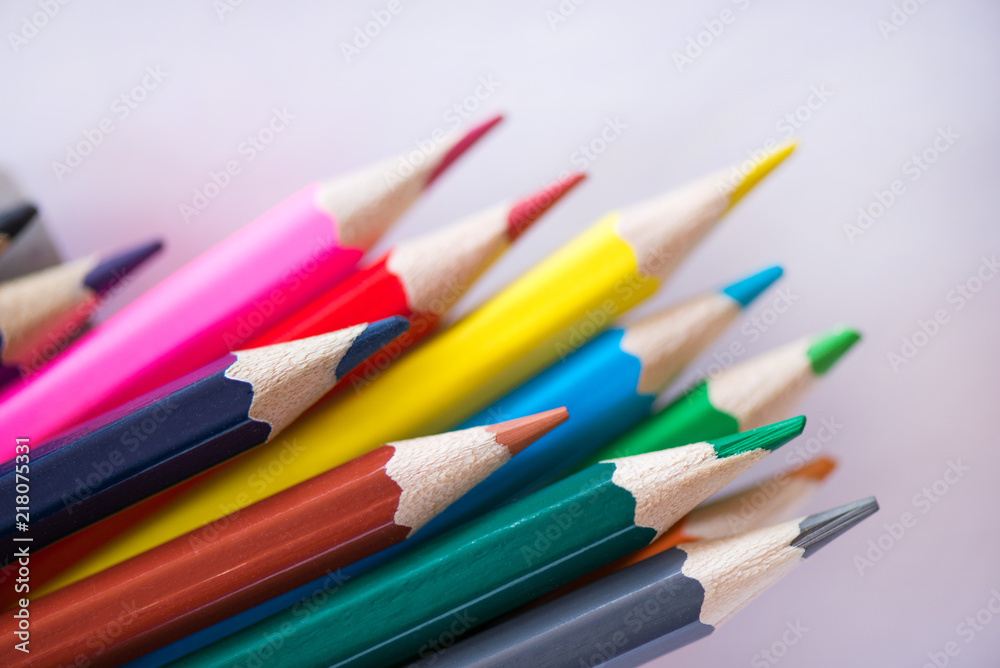 Pile of sharp coloured drawing pencils on table. Rainbow colors red, yellow, blue, green, purple. Concept of art, crafts and kids having fun Pile of sharp coloured drawing pencils on table. Rainbow colors red, yellow, blue, green, purple. Concept of art, crafts and kids having fun