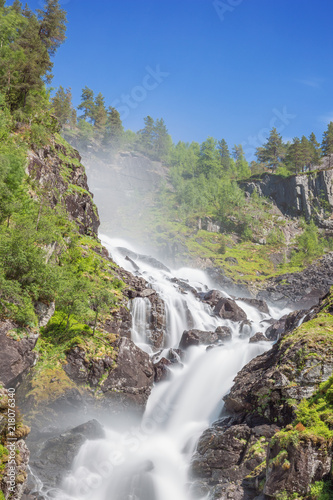 Long exposure of the right branch of the Latefossen  seen from the bridge of the main road. Due to the long exposure there is some blur in the foliage.