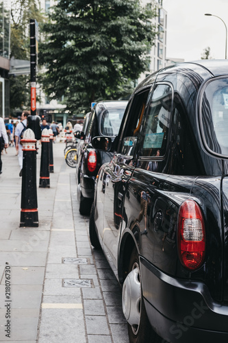 Fototapet Row of Black cabs parked on a side of the road in City of London, London's famous financial district