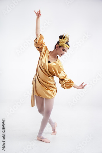 The beauty lady is wearing glod dress ,putbutterfly crown on head,wear ballet shoes,posing basic ballet pattern,for practice