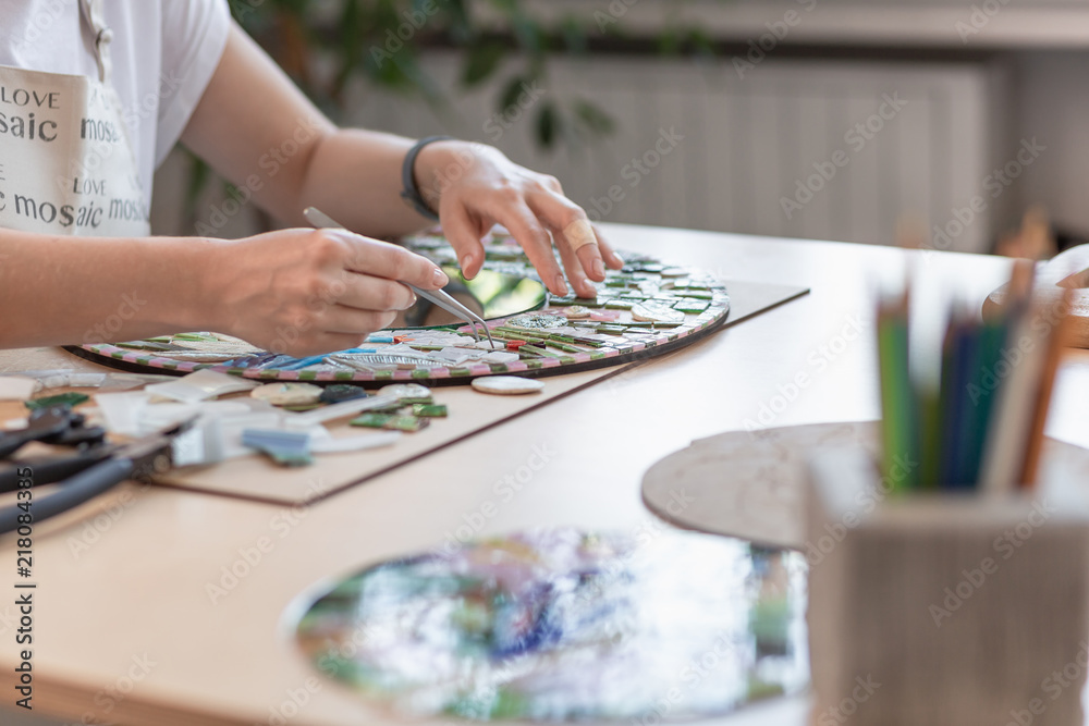 Fototapeta premium Hands of master working on new modern colorful mosaic. Close-up