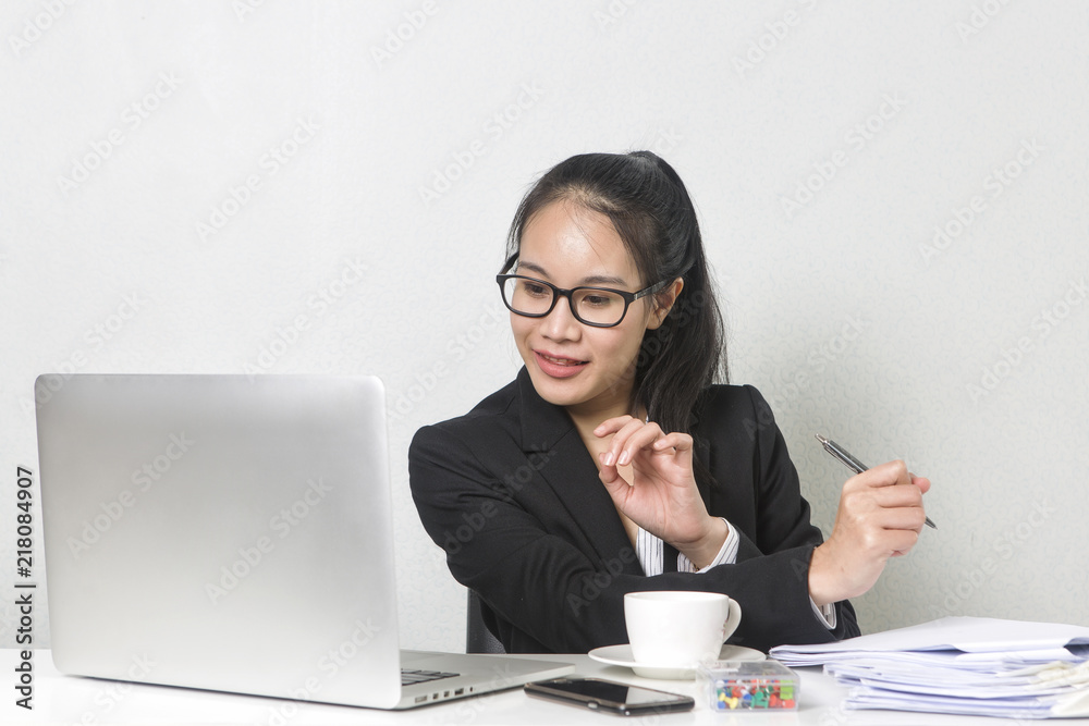Happy business Asian woman working with laptop at white working table, diligent professional working woman drinking coffee while working on laptop computer. Happy business Asian woman working with laptop at white working table, diligent professional working woman drinking coffee while working on laptop computer.
