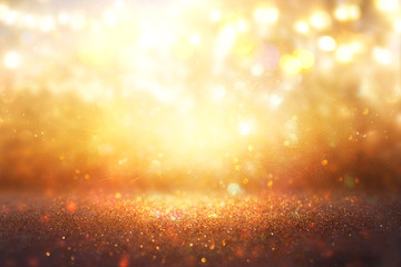 blurred abstract photo of light burst among trees and glitter golden bokeh lights.