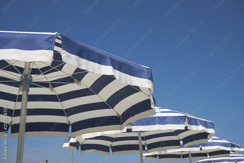 Milano Marittima, Italy - August 03, 2018 : Blue and white striped parasol  Stock Photo | Adobe Stock