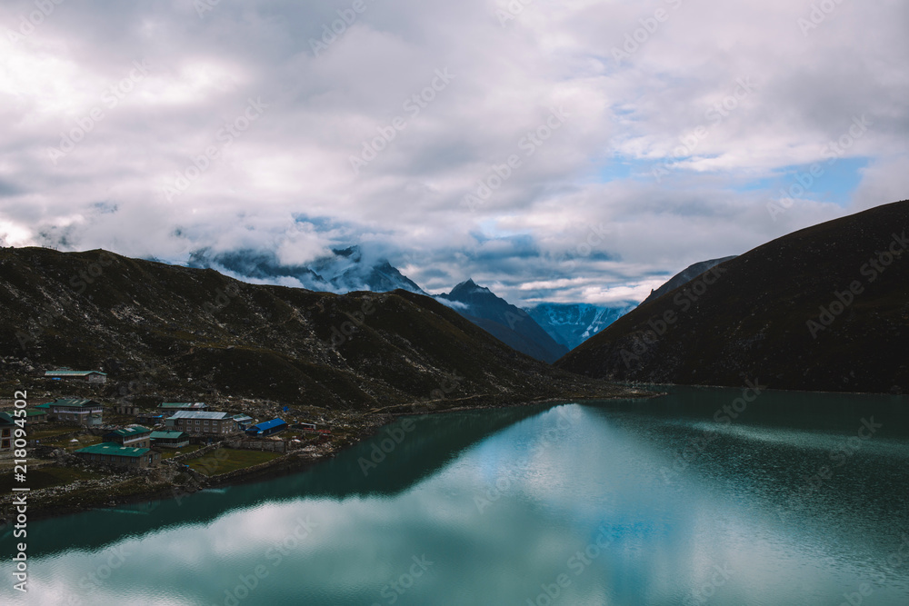 Himalayas mountains. Lake in the mountains, rocks in clouds. View on the lake Gokyo Ri not far from Everest. Colorful landscape with beautiful rocks and dramatic cloudy sky. Nature background.
