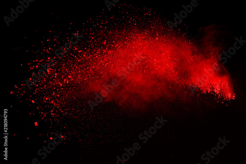 Abstract of red powder explosion on black background. Red powder splatted isolate. Colored cloud. Colored dust explode. Paint Holi.