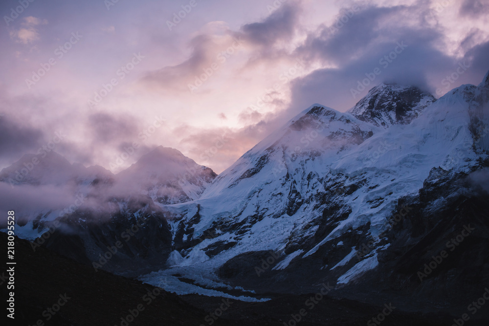 Himalayas landscape. Mountain range with trail in mist and clouds, dark sky with dim sunlight in the background. Stormy weather in mountains. Trekking in Himalaya mountains, Nepal. Nature landscape. Himalayas landscape. Mountain range with trail in mist and clouds, dark sky with dim sunlight in the background. Stormy weather in mountains. Trekking in Himalaya mountains, Nepal. Nature landscape.