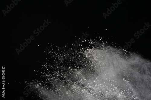 White powder explosion isolated on black background. Colored dust splatted.