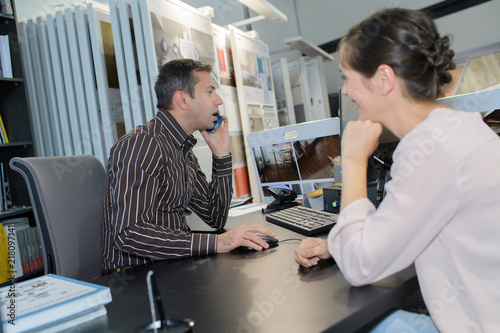 Salesman on telephone while customer waits