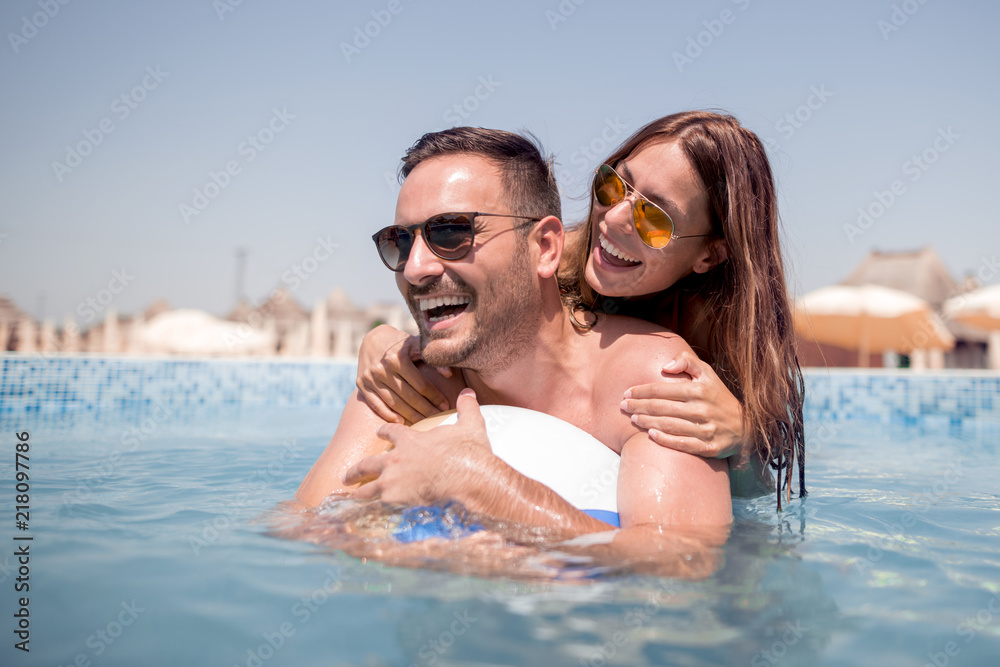 Young couple on the swimming pool enjoying together