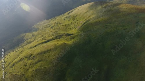 Aerial of a transparent oval UFO flying over a mountsin in the Carpathians photo