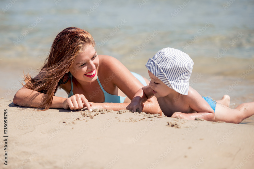 Fototapeta premium Mother and son having fun together on beach