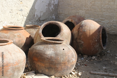 Group of several traditional big clay jars to storage water abandoned in the street. © Rafa