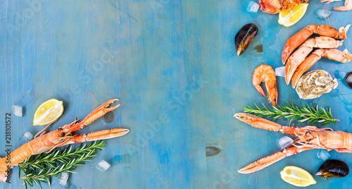 Fresh seafood flat lay frame with copy space on blue wooden background banner