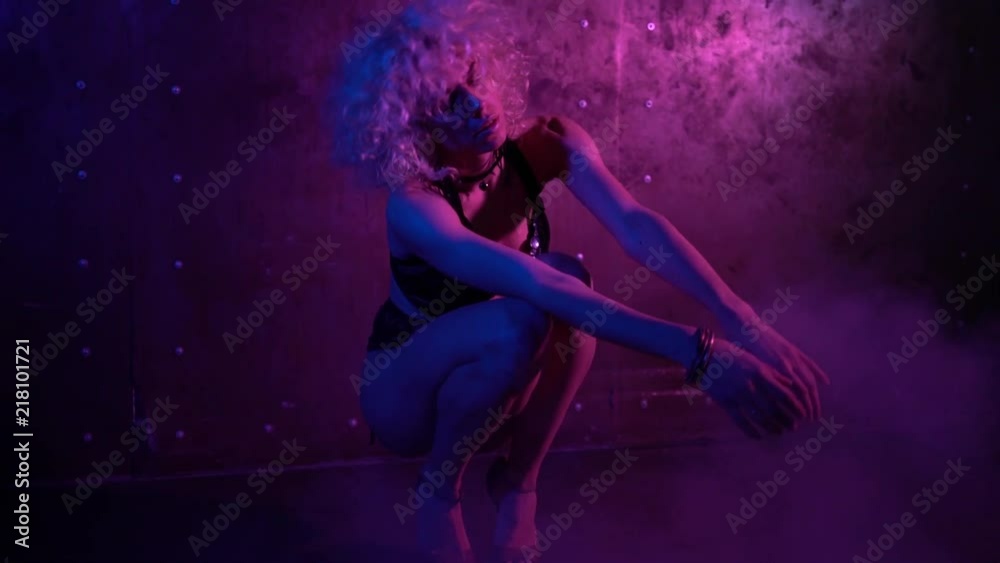 Attractive young woman with curly blond hair wearing lingerie dancing on the dark room floor. Steam. Handheld slow motion medium shot Attractive young woman with curly blond hair wearing lingerie dancing on the dark room floor. Steam. Handheld slow motion medium shot