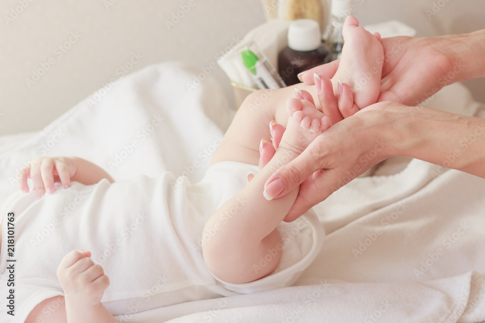Body of a baby and hands of mother, soft focus background Body of a baby and hands of mother, soft focus background