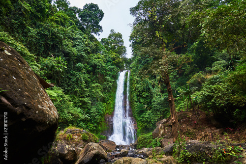 Beautiful waterfall in green tropical forest. View of the falling water with splash of water makes. Nature landscape. Morning view on hidden majestic waterfall in the deep rain forest jungle. .