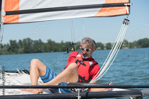 man sailing and dreams on river at summer day