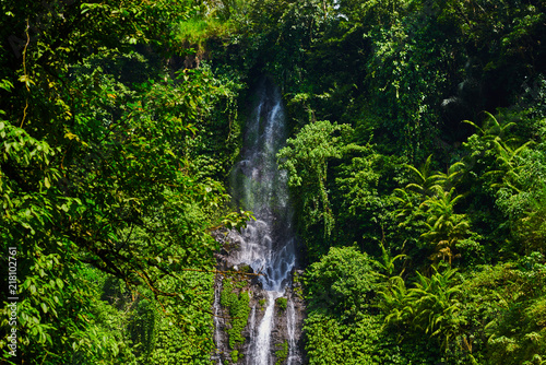 Sekumpul waterfall on Bali island Indonesia. Majestic waterfall in the rainforest jungle. View of amazing beautiful waterfall with sunlight.bNature landscape. Travel and adventure concept. photo