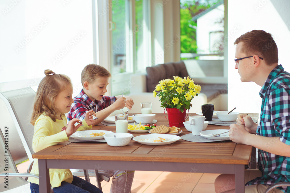 Happy young family having fun during breakfast on terrasse at home Happy young family having fun during breakfast on terrasse at home