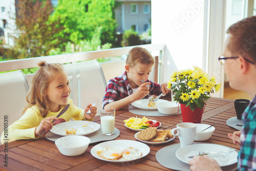 Happy young family having fun during breakfast on terrasse at home © spass