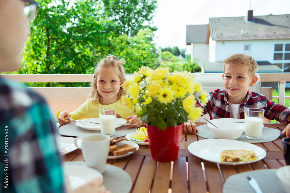 Happy young family having fun during breakfast on terrasse at home Happy young family having fun during breakfast on terrasse at home