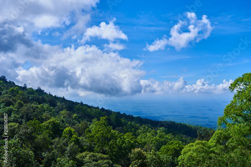 Mountainous tropical forest with blue sky and clouds in valley  high elevation landscape  panoramic view. Tourist lookout towards mountain ranges and hills covered by evergreen rainforests.
