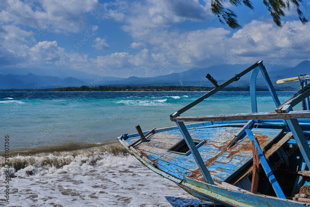 Beautiful tropical beach with old abandoned wooden boat on the azure clear water background on a sunny day. Sea view amazing nature background. The color of the water and beautifully bright. Beautiful tropical beach with old abandoned wooden boat on the azure clear water background on a sunny day. Sea view amazing nature background. The color of the water and beautifully bright.