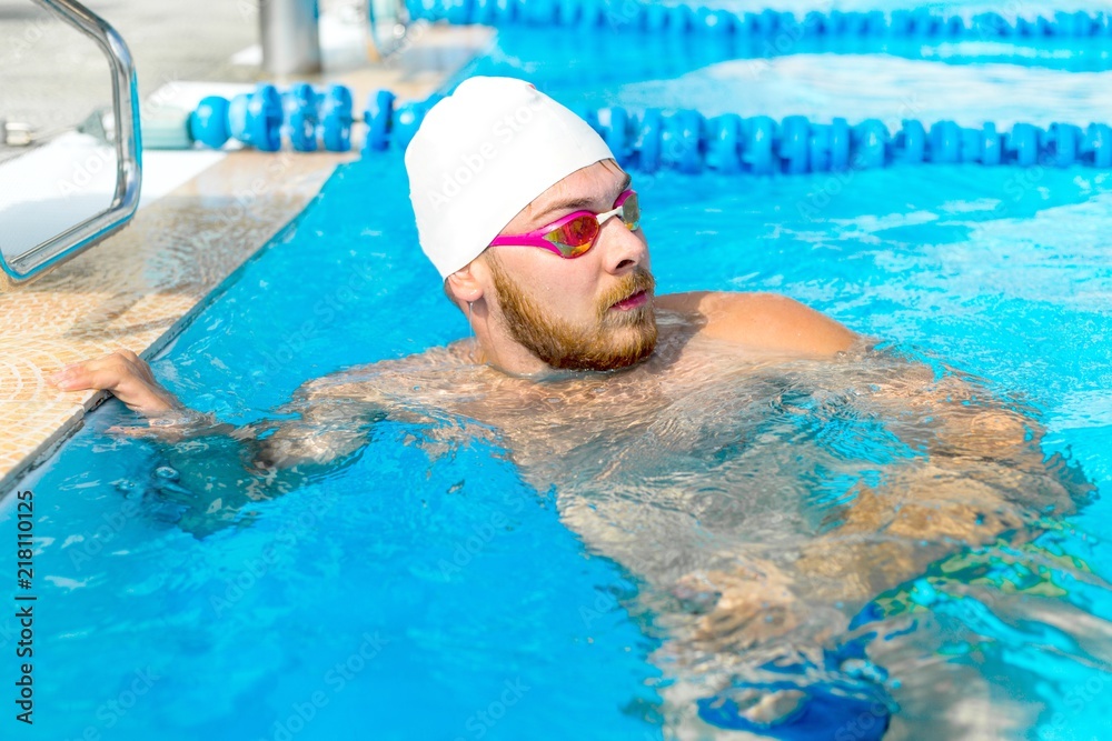Swimmer in a white hat to prepare for a workout standing in the pool