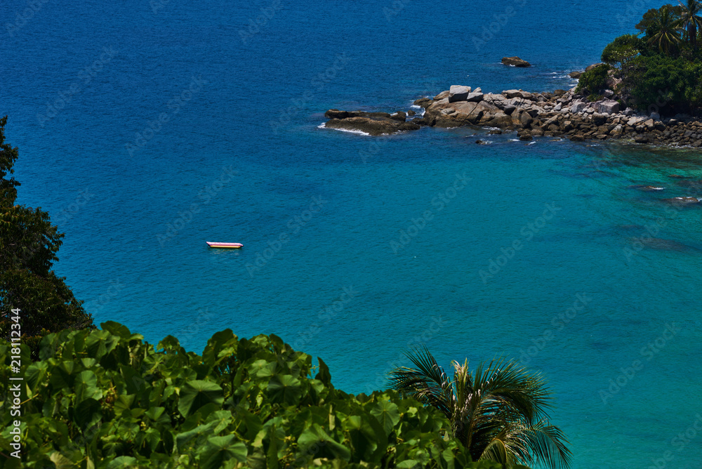 Obraz premium Nature and marine landscape. Turquoise ocean waters. Paradise lagoon, rock bay and large palm trees next to the seashore.