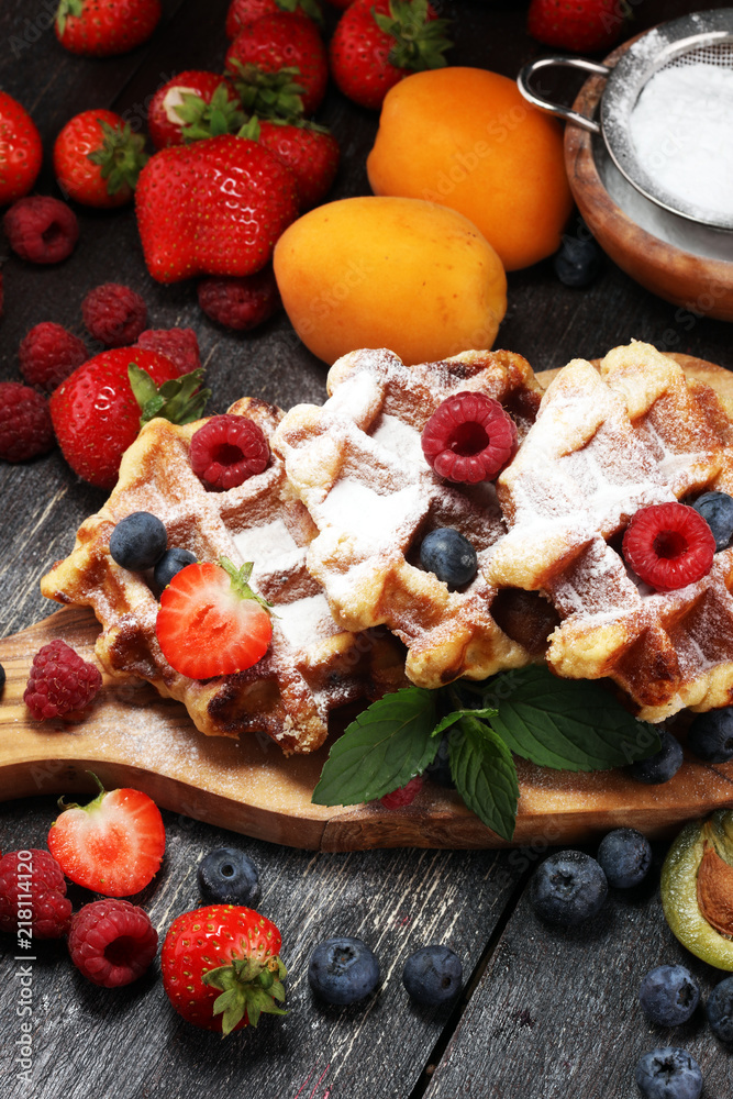 Traditional belgian waffles with fresh mint, sugar and raspberries. Traditional belgian waffles with fresh mint, sugar and raspberries.