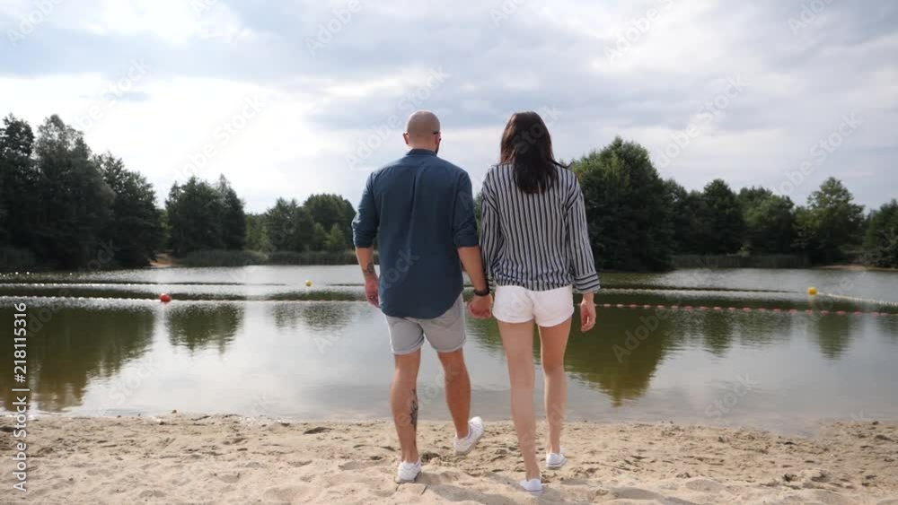 Young couple in love walking on nature holding hand in hand Young couple in love walking on nature holding hand in hand