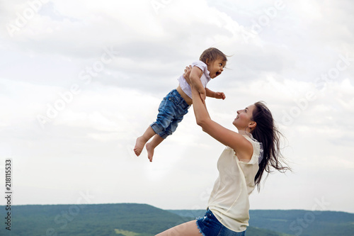 mom throws her son up standing on the mountain in the summer